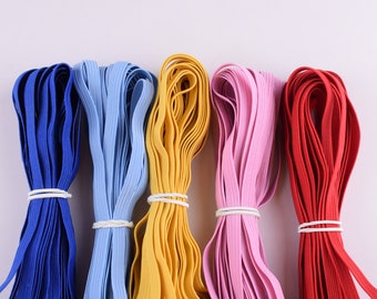 May include: Five spools of elastic cord in different colours: blue, light blue, yellow, pink and red.