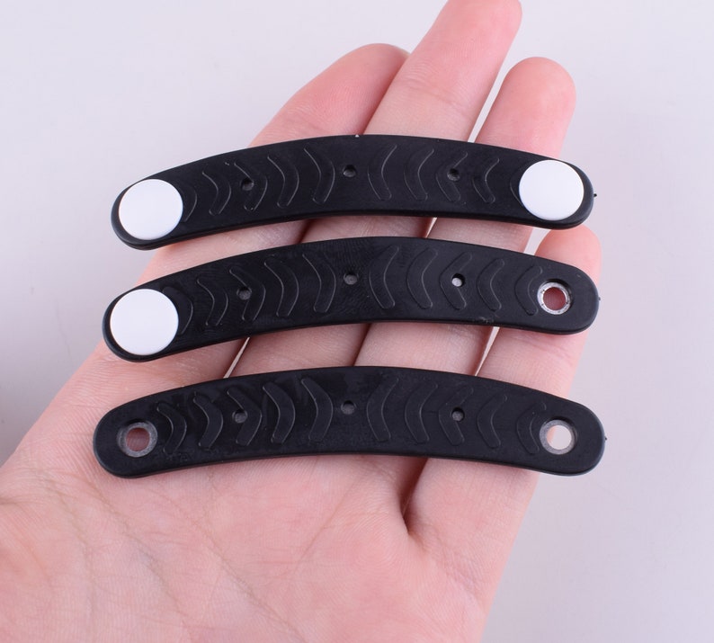 Puede incluir: Tres gomas para el pelo de pl&aacute;stico negro con detalles blancos. Las gomas para el pelo son curvadas y tienen una superficie texturizada.