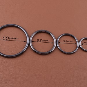 K&ouml;nnte beinhalten: Vier schwarze Metallringe in verschiedenen Gr&ouml;&szlig;en. Die Ringe haben einen Durchmesser von 50 mm, 35 mm, 30 mm und 19 mm.