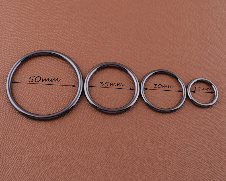 K&ouml;nnte beinhalten: Vier schwarze Metallringe in verschiedenen Gr&ouml;&szlig;en. Die Ringe haben einen Durchmesser von 50 mm, 35 mm, 30 mm und 19 mm.
