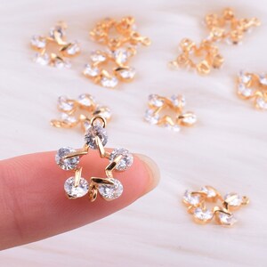 May include: Gold-tone star-shaped charms with clear rhinestones. The charms are perfect for jewelry making, scrapbooking, and other craft projects.