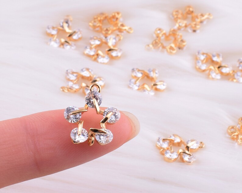 May include: Gold-tone star-shaped charms with clear rhinestones. The charms are perfect for jewelry making, scrapbooking, and other craft projects.