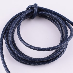 May include: A close-up of a navy blue braided leather cord. The cord is coiled and ready for use in crafting projects.