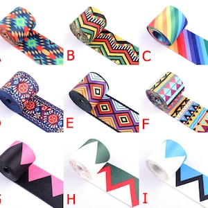 Könnte beinhalten: Neun verschiedene gemusterte Bandborten mit verschiedenen Farben und Designs. Die Borten sind aufgerollt und in einem Rastermuster angeordnet. Die Borten sind alle etwa 2,5 cm breit.