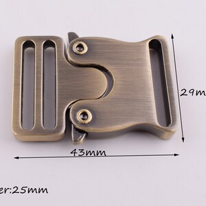 May include: Antique gold metal buckle with a 25 mm inner width, measuring 43 mm long and 29 mm wide.