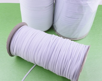 May include: Three spools of white elastic string, wound tightly and ready for use in crafting projects.