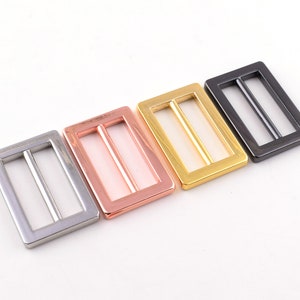 May include: Four metal slider buckles in different finishes: silver, rose gold, gold, and black.