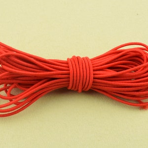 May include: A bundle of bright red elastic cord, tightly wound and ready for use. The cord is a vibrant, solid color, and appears to be made of a stretchy, durable material. The cord is likely used for crafting, sewing, or other DIY projects.