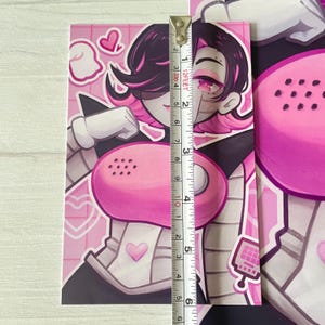 May include: A pink and white illustration of a character with black hair and a pink phone. The character is wearing a white and gray outfit with a pink heart on the chest. The background is pink with white hearts.