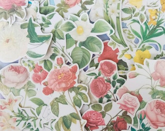 May include: A collection of die-cut stickers featuring botanical illustrations of various flowers including pink, red, and yellow roses, white lilies, and green foliage. The stickers are arranged in a dense overlapping cluster on a light surface.