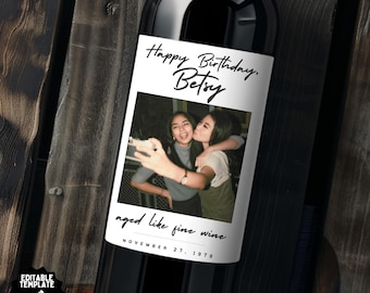 May include: A white wine bottle label with a Polaroid-style photo of two women smiling and taking a selfie. The text on the label reads "Happy Birthday, Betsy aged like fine wine November 27, 1978".