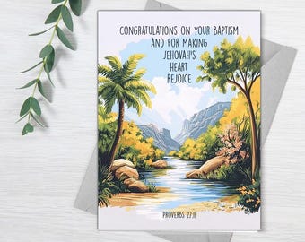 May include: A greeting card with a tropical landscape featuring a river, palm trees, and mountains. The card reads "Congratulations on your Baptism and for making Jehovah's heart rejoice. Proverbs 27:11"