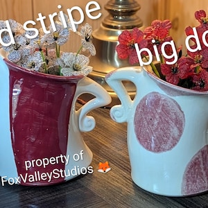 May include: Two ceramic vases with handles, one featuring a vertical red stripe and the other decorated with large red dots. The vases contain artificial flowers. Text on the image reads red stripe, big dots, and property of FoxValleyStudios.