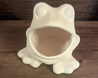 May include: White ceramic frog planter with a large open mouth. The frog is sitting on a wooden surface.