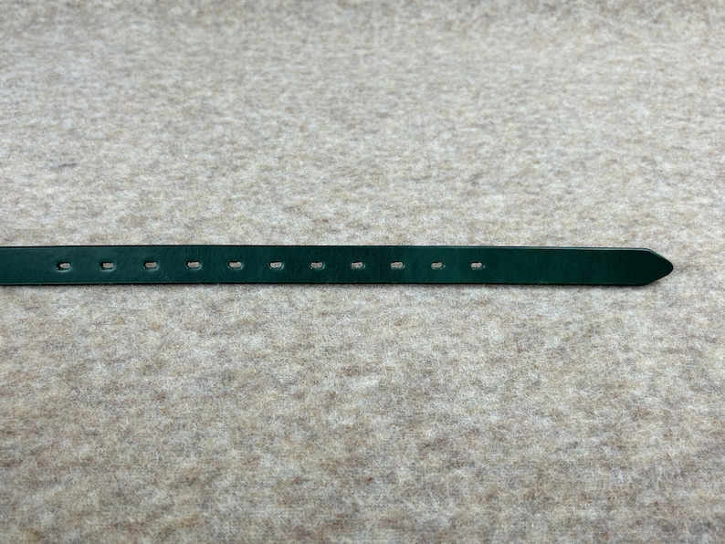 May include: A dark green leather belt with multiple evenly spaced holes for adjusting the fit.