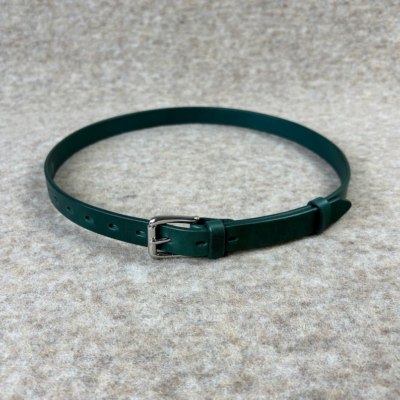 May include: A dark green leather belt with a silver buckle.