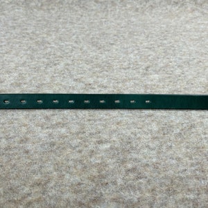 May include: A dark green leather belt with multiple evenly spaced holes for adjusting the fit.