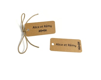 May include: Two brown paper gift tags with the text "Alice et Rémy" and a simple arrow design. The tags are tied together with twine.