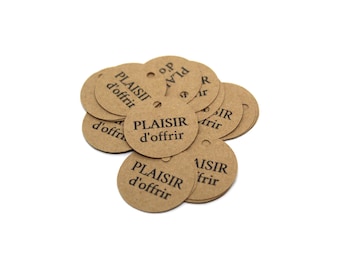 May include: A pile of round, brown gift tags with a small hole at the top. The tags have the words "PLAISIR d'offrir" printed in black, a French phrase meaning "pleasure to offer."