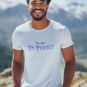 Puede incluir: Una camiseta blanca con un gráfico negro y azul que dice "I'm Art I'M PERFECT".