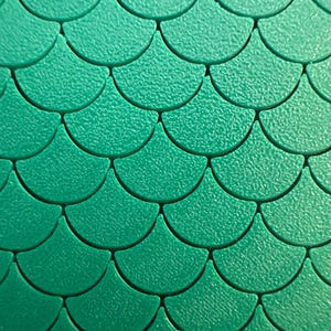 May include: A repeating pattern of teal-colored, semi-circular shapes arranged in an overlapping, scale-like formation. Each individual element features a textured, matte surface finish, creating a consistent and uniform geometric design across the entire view.