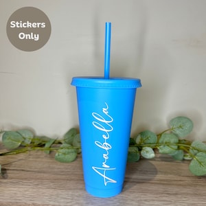 May include: A vibrant blue tumbler with a matching lid and straw. The name "Arabella" is written in white script on the side of the cup. The text "Stickers Only" is in a circle in the upper left corner.