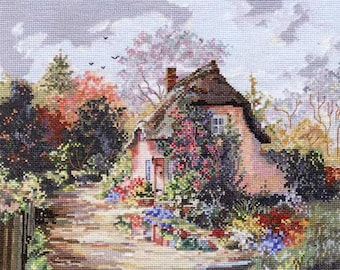 May include: A quaint cottage with a thatched roof sits nestled among lush greenery. The cottage is painted a soft pink and has a charming window with white trim. The surrounding garden is bursting with colorful flowers, creating a picturesque scene.