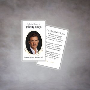 May include: A white memorial card with a black border and gold accents. The card features a photo of a man in a suit and a poem titled "He Only Takes The Best". The text reads "In Loving Memory of Johnny Lingo, November 5, 1989 - January 20, 2024".