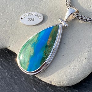 Puede incluir: Un colgante en forma de l&aacute;grima con una piedra preciosa azul y verde engastada en plata de ley. El colgante est&aacute; marcado con "Johnny Rock 925".