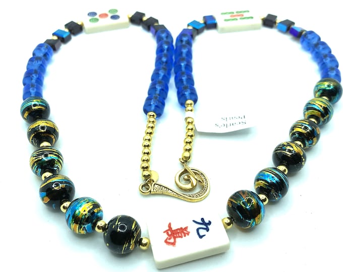 Blue necklace with 3 bone mahjong tiles.
