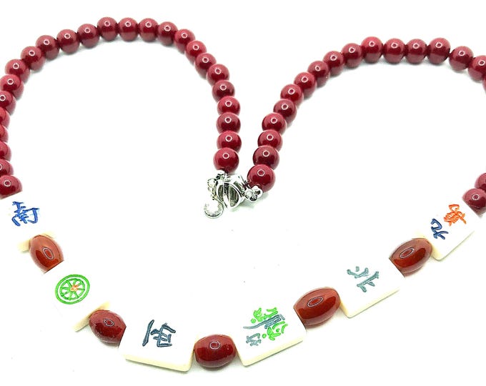 Red bead necklace with small, bone, mahjong tiles.