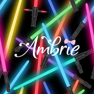 May include: A black background is filled with colorful lightsabers in shades of red, pink, blue, green, and yellow. The word "Ambrie" is written in white script, with a pink bow tie above the name. The lightsabers are angled in various directions.