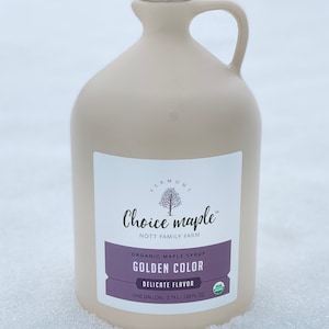 May include: A gallon jug of Vermont Choice maple syrup, a golden color, with a delicate flavor. The label says "Organic Maple Syrup, Golden Color, Delicate Flavor, One Gallon - 3.79 L - 128 fl oz".