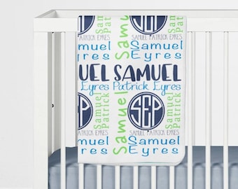 May include: A white baby blanket with a blue and green monogram design. The blanket features the name "Samuel" repeated in a variety of fonts and sizes. The monogram is a circle with the letters "SEP" inside.