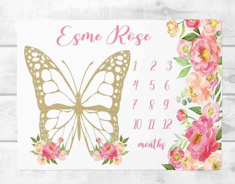 Puede incluir: Una manta blanca para hitos de beb&eacute; con una mariposa dorada con purpurina y detalles florales rosas. La manta tiene los n&uacute;meros del 1 al 12 y el texto "Esm&eacute; Rose" y "meses".