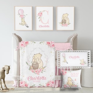 Puede incluir: Un juego de guardería con ilustraciones de Winnie the Pooh. El conjunto incluye impresiones artísticas enmarcadas, una cuna, una manta, un protector de cuna y un cojín decorativo. La combinación de colores es rosa suave y crema, con detalles florales y el nombre "Charlotte".