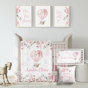 May include: A nursery set featuring a crib, bedding, and wall art. The set includes a crib, blanket, crib sheet, and pillow, all with a pink and floral hot air balloon design. The wall art includes three framed prints with inspirational quotes.