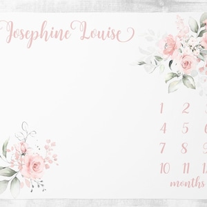 May include: A white baby milestone blanket with a pink floral design and the name Josephine Louise printed at the top. The blanket has numbers 1 through 12 printed on it to mark each month of the baby's first year.