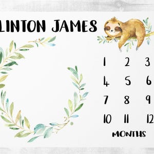 Puede incluir: Manta de hito blanca con el nombre "CLINTON JAMES" en escritura negra. Presenta una ilustración de perezoso en acuarela, una corona de hojas y los números 1-12 con la palabra "MONTHS" debajo. Ideal para fotos de bebés.