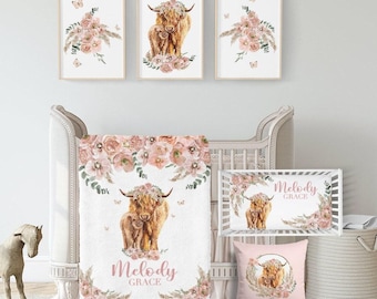 May include: A nursery set featuring a watercolor design with a Highland cow and floral accents. The set includes framed art prints, a crib blanket, a crib bumper, and a decorative pillow. The color palette is soft, with pinks, browns, and greens.