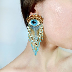 Evil eye beaded earrings. Gold, white and blue fringe earrings.