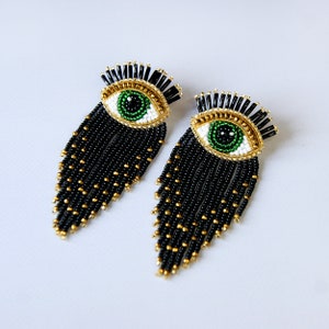 Kolczyki z koralikami „złe oko”. Kolczyki z frędzlami w kolorze czarnym i złotym.