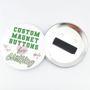 May include: A white round button with a green and pink design. The button says "Custom Magnet Buttons for Clothing" with a pink heart and sparkles. The back of the button is silver with a black magnet.