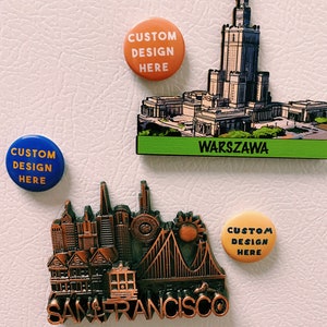 May include: Three refrigerator magnets featuring city skylines. The magnets are round and feature the text "Custom Design Here". The city skylines are of San Francisco, Warsaw, and an unidentified city.