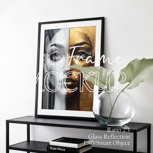 May include: A framed art print featuring a split portrait of a woman's face, half in black and white, the other half in gold. The frame is black, and the artwork is displayed on a black shelf with a glass vase and a book. The text "Frame Mockup" is overlaid on the image.