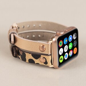 Może przedstawiać: Złoty pasek do Apple Watch z nadrukiem lamparta i złotą Apple Watch w kolorze r&oacute;żowego złota.