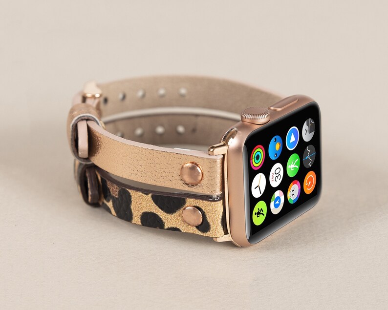 Może przedstawiać: Złoty pasek do Apple Watch z nadrukiem lamparta i złotą Apple Watch w kolorze r&oacute;żowego złota.