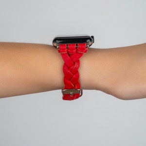 Puede incluir: Una correa de reloj de cuero trenzado roja para un reloj inteligente.