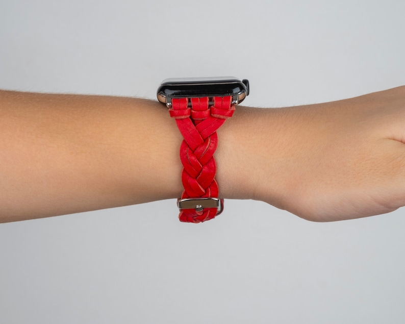 Puede incluir: Una correa de reloj de cuero trenzado roja para un reloj inteligente.