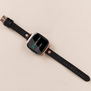 May include: Black fitness tracker with a rose gold band and a black screen displaying 12,000 steps and 67 bpm.